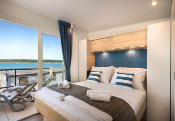 Moderne slaapkamer in Marbello Home, Valamar Camping Istra, Kroatië met balkon en zeezicht.