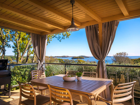Overdekt terras met eettafel bij Bella Vista Home, Valamar Camping Istra, Kroatië, zicht op zee.
