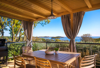 Overdekt terras met eettafel bij Bella Vista Home, Valamar Camping Istra, Kroatië, zicht op zee.