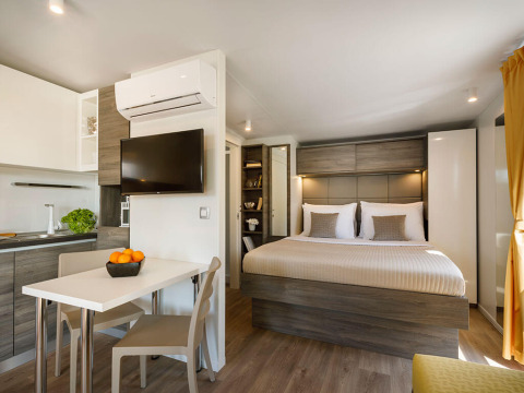 Moderne interiør i Bella Vista Chalet på Valamar Camping Istra, Kroatien med soveværelse og tekøkken.