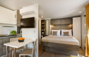 Modern interieur van Bella Vista Chalet op Valamar Camping Istra, Kroatië, met slaapkamer en keukenhoek.