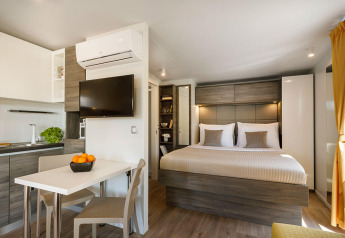 Modern interieur van Bella Vista Chalet op Valamar Camping Istra, Kroatië, met slaapkamer en keukenhoek.