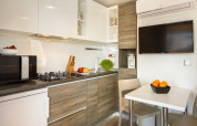 Moderne keuken en eetruimte in het Bella Vista Chalet op Valamar Camping Istra in Kroatië, met tv en toestellen.