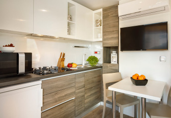 Moderne keuken en eetruimte in het Bella Vista Chalet op Valamar Camping Istra in Kroatië, met tv en toestellen.