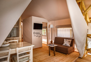 Interno di una Sunset Premium Glamping Tent al Valamar Camping Istra, Croazia, con comfort moderni.