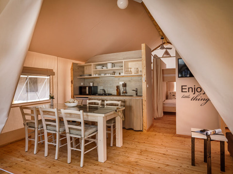 Interieur van Sunset Premium Glamping Tent met eettafel en keuken op Valamar Camping Istra in Kroatië.