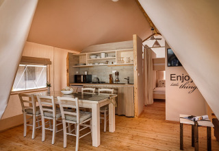 Interieur van Sunset Premium Glamping Tent met eettafel en keuken op Valamar Camping Istra in Kroatië.