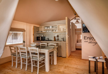 Interior de la Sunset Premium Glamping Tent con comedor y cocina en Valamar Camping Istra, Croacia.