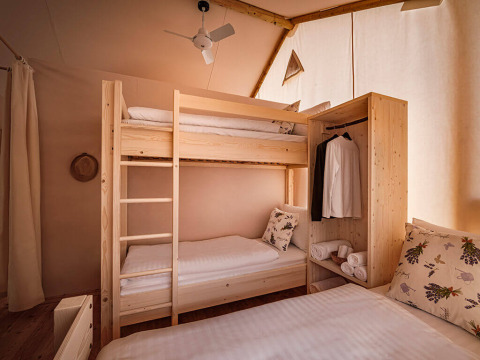 Gezellige slaapkamer in de Sunset Premium Glamping Tent bij Valamar Camping Istra, Kroatië, met stapelbedden.