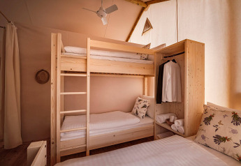 Accogliente camera da letto nella Sunset Premium Glamping Tent al Valamar Camping Istra, Croazia, con letti a castello.