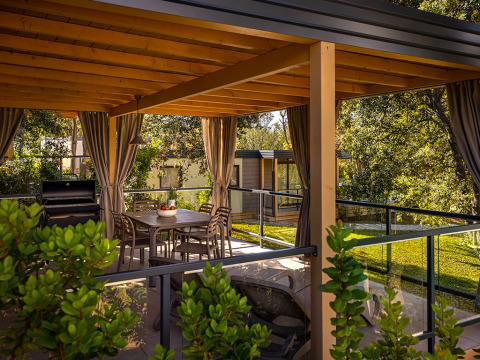 Buitenterras van Marina Suite bij Valamar Camping Istra, Kroatië, met eettafel, barbecue en pergola.