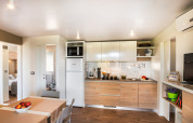 Moderne keuken en eetruimte in het Bella Vista Home lodge met houten vloer en stijlvolle inrichting.