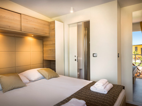 Moderne slaapkamer bij Bella Vista Home lodge met tweepersoonsbed, houten accenten en veel natuurlijk licht.