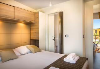 Moderne slaapkamer bij Bella Vista Home lodge met tweepersoonsbed, houten accenten en veel natuurlijk licht.