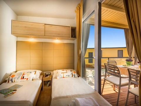 Knusse slaapkamer met twee eenpersoonsbedden in Bella Vista Home, met toegang tot een zonnig terras met eethoek.