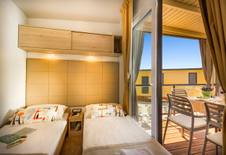 Knusse slaapkamer met twee eenpersoonsbedden in Bella Vista Home, met toegang tot een zonnig terras met eethoek.