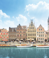 Edificios históricos coloridos y barcos en un canal urbano, perfecta para vacaciones de glamping.