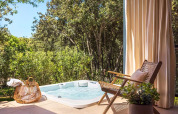 Buitenjacuzzi en gezellige stoel aan Sunset Villa, Valamar Camping Istra, tussen bomen in Kroatië.