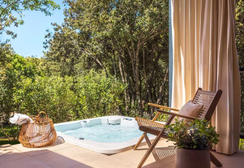 Jacuzzi all'aperto e sedia accogliente presso Sunset Villa, Valamar Camping Istra, tra alberi in Croazia.