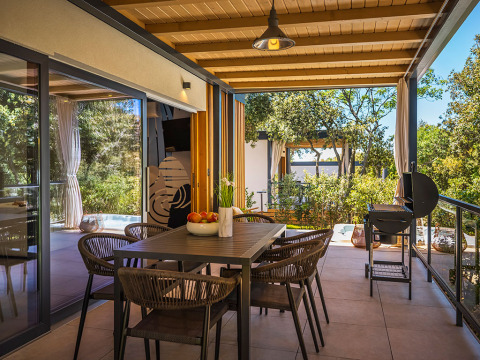 Buitenterras met eetruimte en barbecue aan Sunset Villa met jacuzzi bij Valamar Camping Istra in Kroatië.