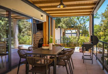 Zona pranzo esterna e terrazza con barbecue nella Sunset Villa con jacuzzi a Valamar Camping Istra in Croazia.