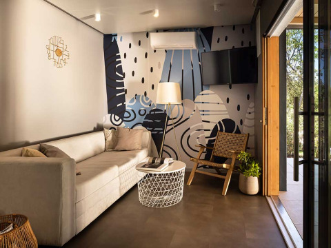 Moderne woonkamer in Sunset Villa met jacuzzi bij Valamar Camping Istra, Kroatië, met artistiek muurschildering.