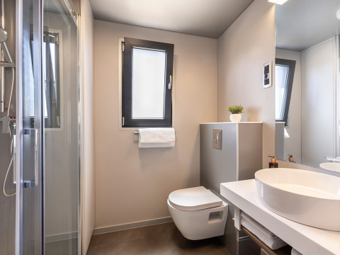 Moderne badkamer met wandtoilet, ronde waskom en douche in Sunset Villa, Valamar Camping Istra, Kroatië.