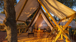 Lujosa tienda safari Sunset Bell con terraza de madera y asientos en Valamar Camping Istra en Croacia.