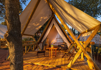 Tenda safari Sunset Bell con terrazza in legno, sedie comode al Valamar Camping Istra in Croazia.