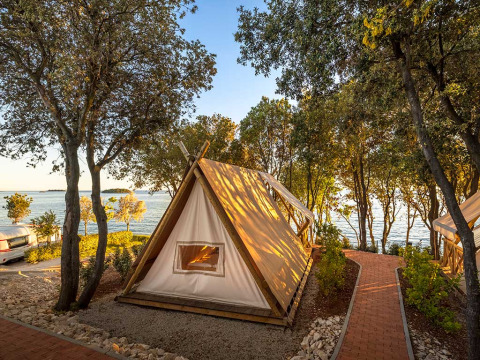 Safari-tent Sunset Bell Tent Seaview bij Valamar Camping Istra in Kroatië, dicht bij zee en omringd door bomen.