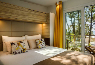 Moderne slaapkamer bij Istra Home op Valamar Camping Istra in Kroatië met groot bed en zicht op het balkon.