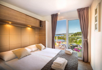Moderne slaapkamer met zeezicht in Bella Vista Home, Valamar Camping Istra, Kroatië, zonnige dag.