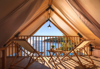 Tenda safari con sedie e tavolo in legno, vista mare da Sunset Glamping Tent Seaview, Valamar Camping Istra, Croazia.