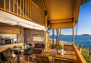 Safari glamping tent aan zee met houten terras en prachtig uitzicht op Valamar Camping Istra, Kroatië.