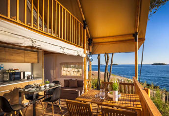 Tenda glamping safari con vista mare, terrazza in legno e cucina moderna al Valamar Camping Istra, Croazia.
