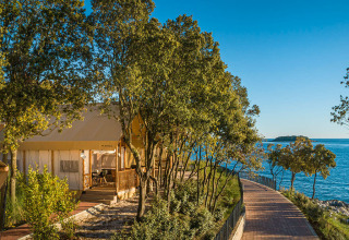 Safari tent Sunset Glamping Tent Seaview bij Valamar Camping Istra in Kroatië, zeezicht en omringd door bomen.