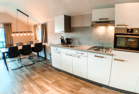 Cuisine moderne et salle à manger dans une Waterlodge au Familievakantiepark Krieghuusbelten, aux Pays-Bas, décor chic.