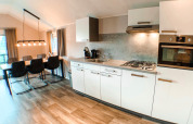 Cucina moderna e zona pranzo in una Waterlodge al Familievakantiepark Krieghuusbelten, Paesi Bassi, dallo stile elegante.