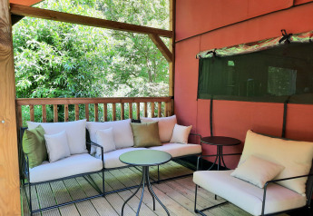 Area lounge esterna alla Wander Lodge nel Vakantiepark Delftse Hout, Paesi Bassi, con comode sedute e verde
