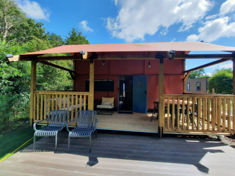 Wander Lodge en Vakantiepark Delftse Hout, Países Bajos, con terraza techada y asientos al aire libre.