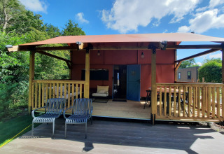 Wander Lodge ved Vakantiepark Delftse Hout, Holland, med overdækket terrasse og udendørs siddepladser.