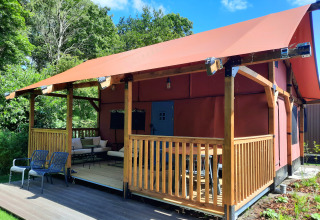 Udendørsbillede af Wander Lodge ved Vakantiepark Delftse Hout i Holland med terrasse og siddeområde.