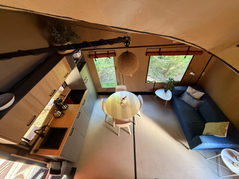 Binnenzicht van Wander Lodge in Vakantiepark Delftse Hout met keukenblok, eettafel en zetel.