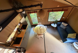 Modernes Lodge-Innenraum mit Küche, Esstisch und Sofa in der Wander Lodge im Vakantiepark Delftse Hout, Niederlande.