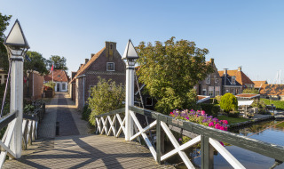 Photo d'un joli pont et de maisons traditionnelles dans un parc de vacances proposant du glamping.