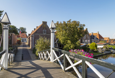 Foto de un pintoresco puente y casas en un parque vacacional que ofrece alojamientos glamping junto al agua.