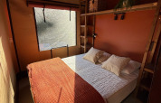 Gemütliches Schlafzimmer in der Wander Lodge im Vakantiepark Delftse Hout, Niederlande, mit Bett.