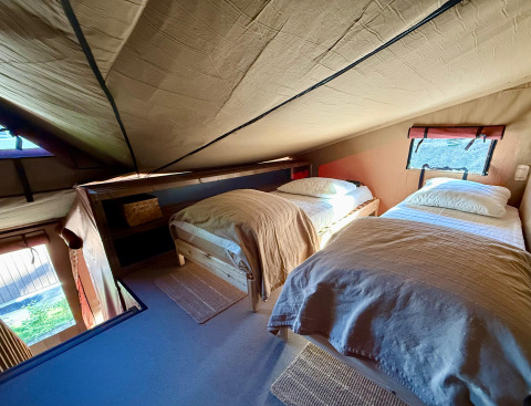 Cozy twin bedroom with slanted ceiling at Wander Lodge in Vakantiepark Delftse Hout, Netherlands.