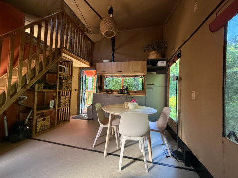 Binnenzicht van Wander Lodge aan Vakantiepark Delftse Hout met eettafel en moderne keukenruimte.