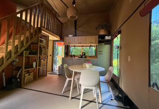 Interior view of Wander Lodge at Vakantiepark Delftse Hout featuring dining table and modern kitchen.